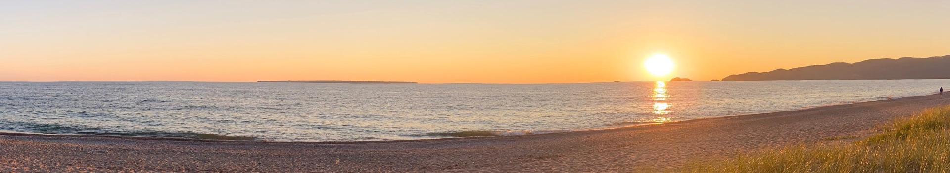 Sun setting over horizon